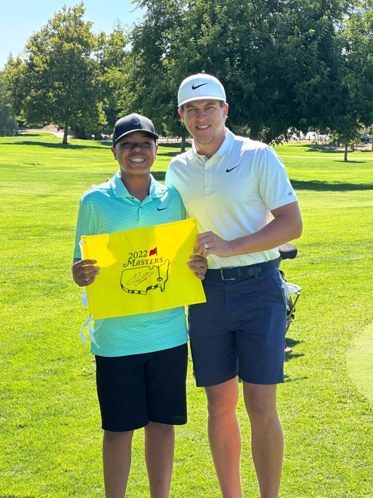 Cameron Champ with closest to the pin winner and signed Masters flag